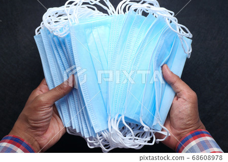 man hand holding surgical face mask, top view man hand holding surgical face mask, top view 68608978