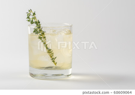 Alcoholic cocktail decorated with thyme in a glass 68609064