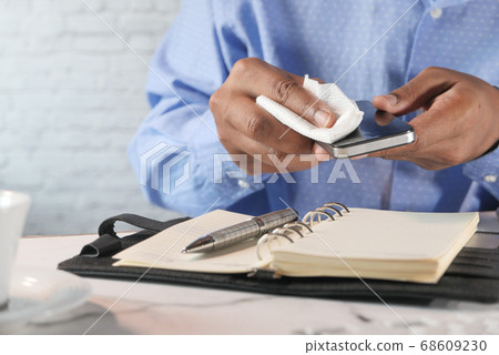 close up of person hand cleaning smart phone. 68609230