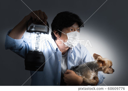 Middle-aged man and Yorkshire Terrier looking for an exit with a lantern in the dark world Middle-aged man and Yorkshire Terrier looking for an exit with a lantern in the dark world 68609776