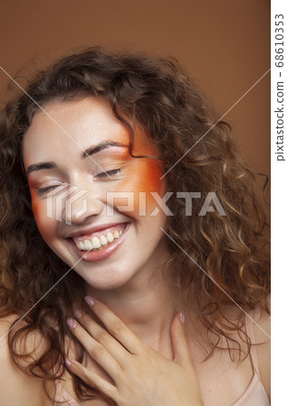young pretty girl with curly hair posing cheerful on brown background, lifestyle people concept 68610353