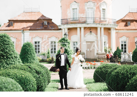 Beautiful bride and groom embracing and kissing on their wedding day outdoors 68611241
