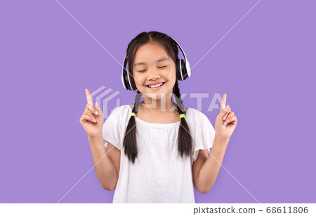 Girl In Earphones Enjoying Listening To Music, Purple Background Girl In Earphones Enjoying Listening To Music, Purple Background 68611806