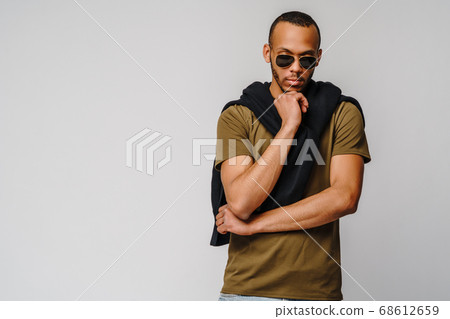 african-american young man in green t-shirt over light grey background with copy space african-american young man in green t-shirt over light grey background with copy space 68612659
