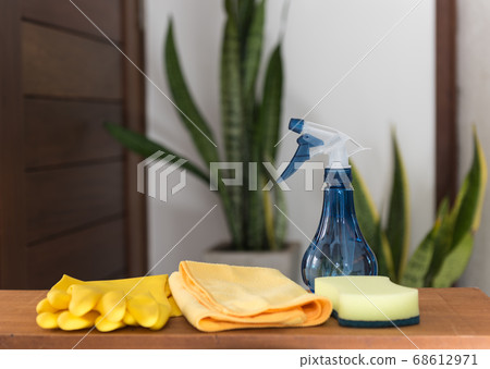 set of cleaning supplies on  wood table in house 68612971