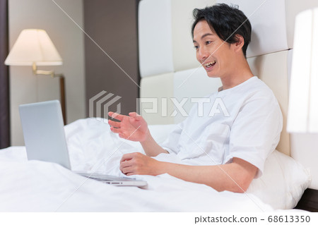 A young man in a futon talking to her in a zoom A young man in a futon talking to her in a zoom 68613350