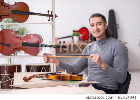 Young male repairman repairing violin 68614041
