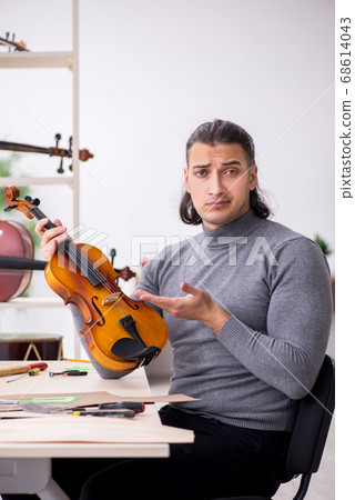 Young male repairman repairing violin 68614043