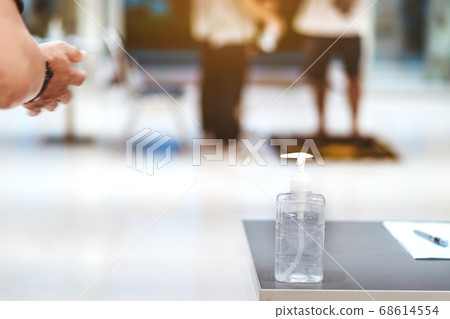 Clear alcohol gel bottles for hand cleaning to prevent the spreading of the corona virus (Covid-19). Place the entrance service with register book for customers before buying in the supermarket. 68614554