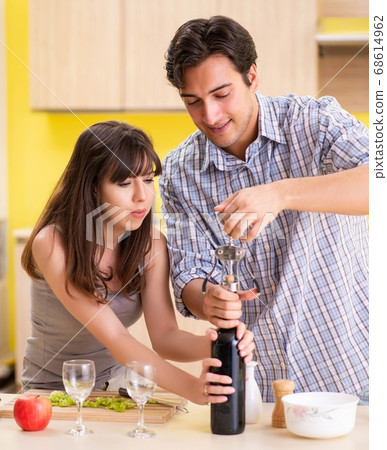 Young couple celebrating wedding anniversary at kitchen Young couple celebrating wedding anniversary at kitchen 68614962