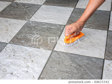 cleaning the tile floor. 68615342