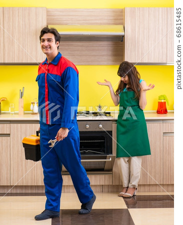 Woman with contractor at kitchen discussing repair 68615485