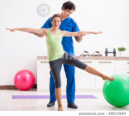 Fitness instructor helping sportsman during exercise 68615694