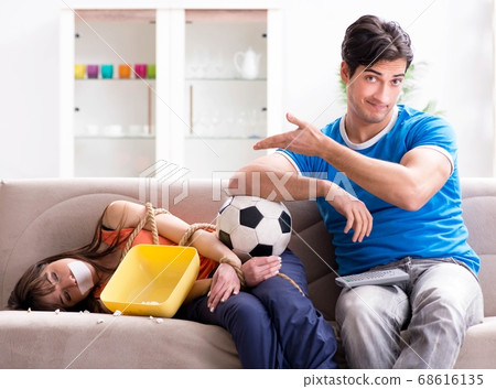Man tying up his wife to watch sports football Man tying up his wife to watch sports football 68616135