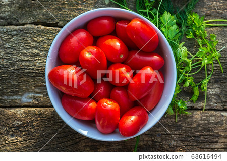 tomatoes in a bowl of a wooden background, top view. selective focus. space for copying text tomatoes in a bowl of a wooden background, top view. selective focus. space for copying text 68616494