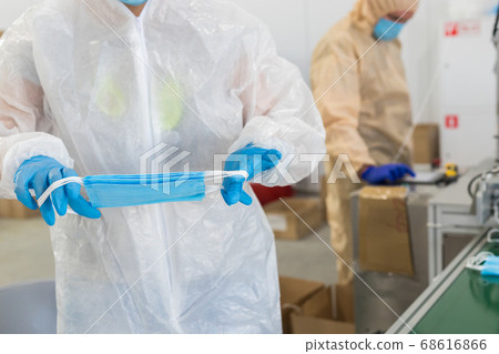 Industrial production of protective medical masks - workers work with masks 68616866