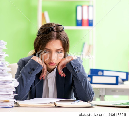 Young female employee very busy with ongoing paperwork 68617226