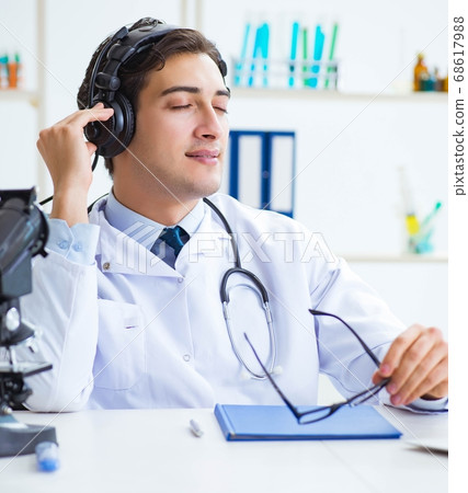 Happy excited doctor listening to music during lunch break in ho Happy excited doctor listening to music during lunch break in ho 68617988
