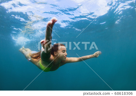 Young woman diving underwater Young woman diving underwater 68618306