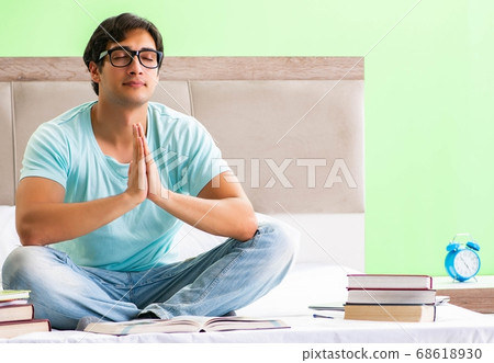 Student preparing for exams at home in bedroom sitting on the be Student preparing for exams at home in bedroom sitting on the be 68618930