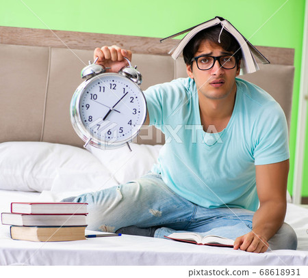 Student preparing for exams at home in bedroom sitting on the be Student preparing for exams at home in bedroom sitting on the be 68618931