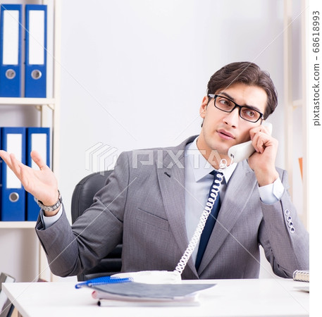 Businessman employee talking on the office phone Businessman employee talking on the office phone 68618993