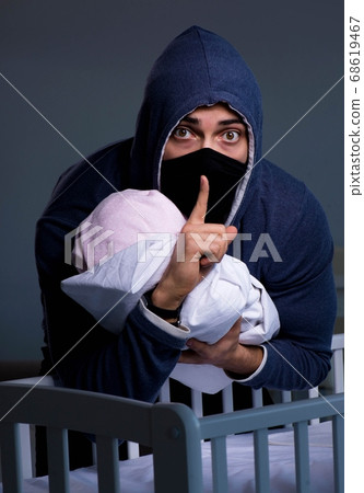Criminal stealing baby in human child traficking concept 68619467