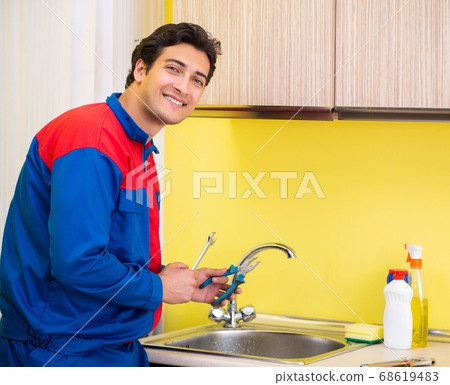 Plumber repairing tap at kitchen Plumber repairing tap at kitchen 68619483