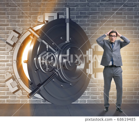 Businessman in front of banking vault door 68619485