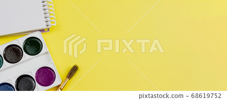 Notebook with paints on a yellow background. Notebook with paints on a yellow background. 68619752
