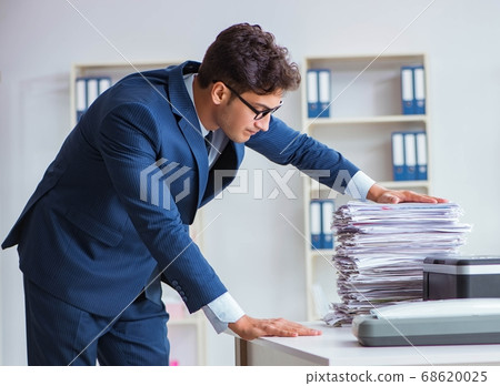 Businessman making copies in copying machine 68620025