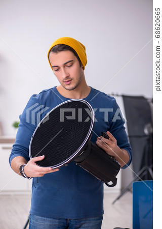 Young male photographer working in the studio Young male photographer working in the studio 68620665