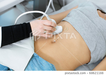 The doctor conducts an ultrasound diagnosis of the The doctor conducts an ultrasound diagnosis of the 68621188