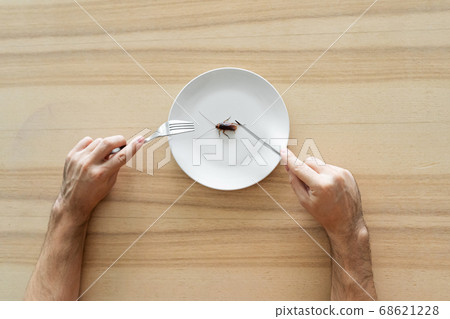 Top view, a man eating a cockroach. Cockroach in a 68621228