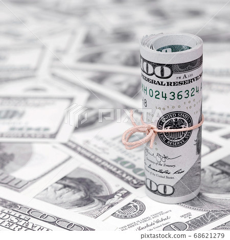 US dollars rolled up and tightened with band lies 68621279