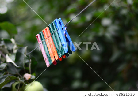 Clothespins on a rope hanging outside house and 68621539