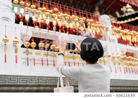 woman take a picture at the golden bells 68621630