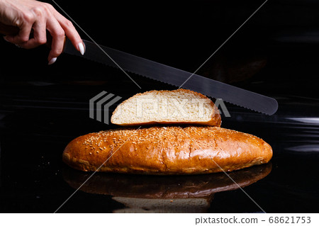 Homemade pastries. Crispy white bread cut with a knife. 68621753