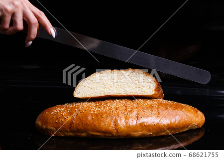 Homemade pastries. Crispy white bread cut with a knife. 68621755