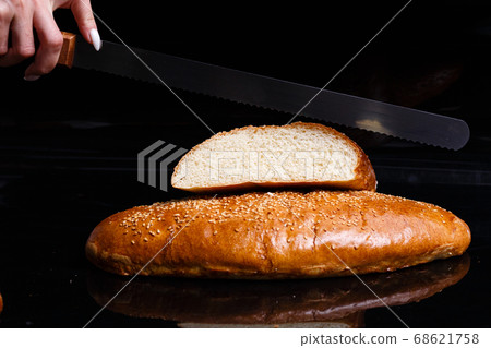 Homemade pastries. Crispy white bread cut with a knife. Homemade pastries. Crispy white bread cut with a knife. 68621758