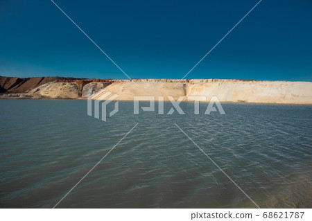 Pond in the desert. White sand mountains and blue water and sky. Pond in the desert. White sand mountains and blue water and sky. 68621787