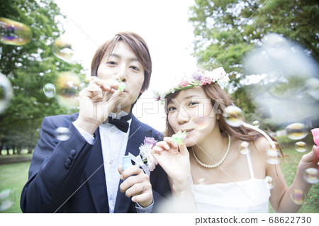 Bride and groom blowing soap bubbles 68622730