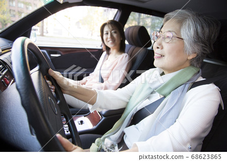 Mother and daughter driving a car Mother and daughter driving a car 68623865