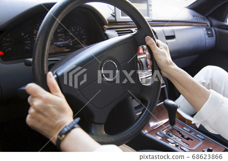 A woman driving a car 68623866