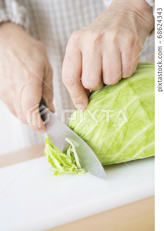 Senior woman cutting cabbage 68624343