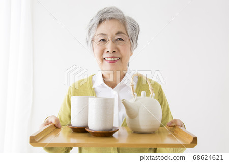 Senior woman carrying tea Senior woman carrying tea 68624621