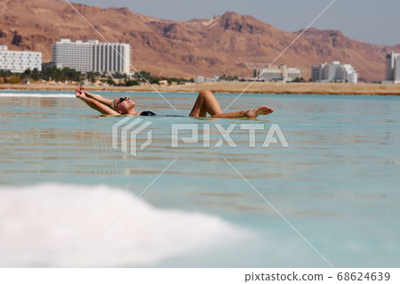 Sexy blonde woman in a black swimsuit lies on the dead sea Israel  68624639