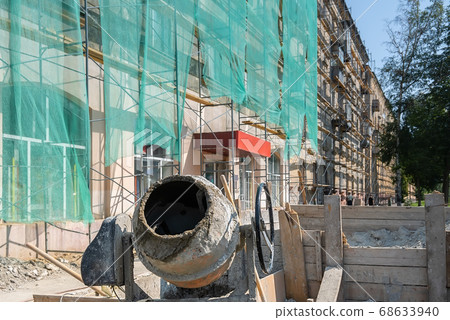 a construction concrete mixer stands near the building being repaired a construction concrete mixer stands near the building being repaired 68633940