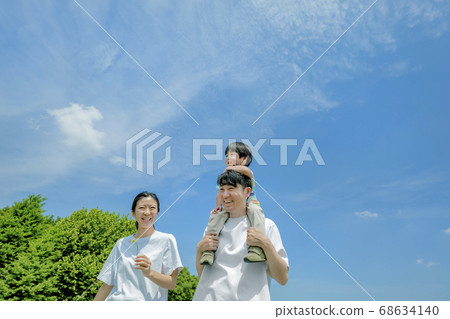 Three-person family playing in the park Three-person family playing in the park 68634140