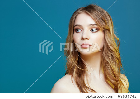 Beautiful young woman in color lights over blue 68634742